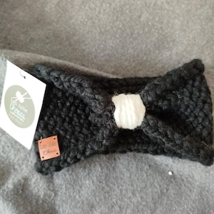 Peut inclure: Un serre-tête noir en tricot avec un nœud blanc et une étiquette en cuir marron qui dit "Les Jolie Choses".