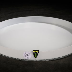 Könnte beinhalten: Runder weißer Tablett mit einem silbernen Perlenrand. Das Tablett hat eine Wasserwaage an der Seite und einen Aufkleber mit der Aufschrift "Crooky Projects" und "Etsy Shop".