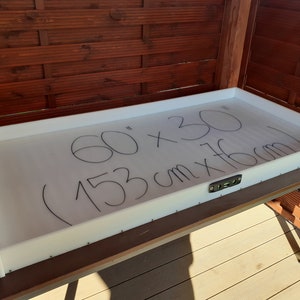 Peut inclure: Plateau en plastique blanc avec inscription au marqueur noir indiquant les dimensions : 60" x 30" (153 cm x 76 cm).