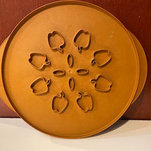 May include: A brown plastic baking pan with eight individual molds shaped like bell peppers. The pan is designed for baking individual portions of food.