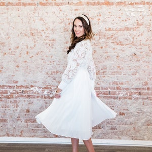 May include: A white lace dress with a white headband and white heels.