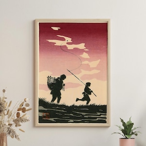 Puede incluir: Impresión enmarcada de una obra de arte japonesa en madera. La obra representa a dos figuras caminando por una zona cubierta de hierba, una llevando una cesta y la otra corriendo con una pértiga larga. El cielo es un degradado de rojo y rosa.