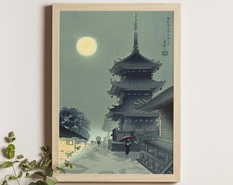 May include: A wood-framed print of a Japanese pagoda under a full moon. The pagoda is a multi-tiered structure with a dark grey roof and a light grey body. The moon is a bright yellow circle in the sky. The print is set against a light blue background. The text in the image reads "東海道五十三次", which translates to "The Fifty-three Stations of the Tōkaidō Road."