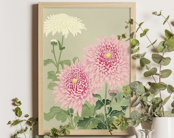 Könnte beinhalten: Ein gerahmter Blumendruck mit zwei großen rosa Chrysanthemen mit gelben Zentren und einer kleineren weißen Chrysantheme. Das Kunstwerk hat grüne Blätter und Stiele vor einem gedämpften grünen Hintergrund, alles in einem hellen Holzrahmen. Der Stil erinnert an japanische Kunst.