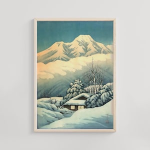 Puede incluir: Una impresión enmarcada de un paisaje invernal con una cordillera nevada y una pequeña cabaña. La obra de arte tiene una estética vintage con suaves azules, blancos y toques de amarillo, evocando una atmósfera serena y fría.