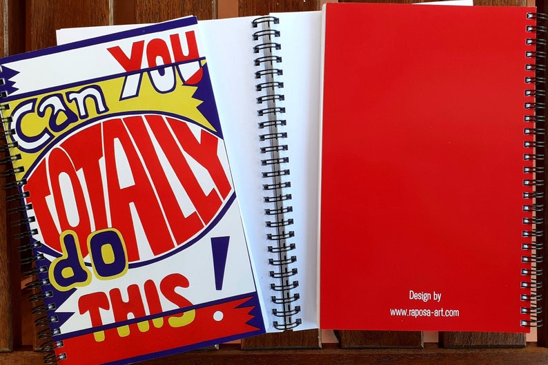以下が含まれることがあります： 赤い表紙に「Can You Totally Do This!」の文字が大胆でカラフルなデザインで描かれた、スパイラル綴じのノート。開いたノートには、白紙のページが並んでいます。裏表紙は、デザイン情報が記載された無地の赤色です。