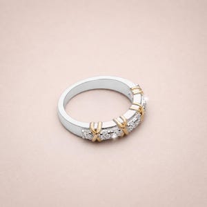 Shop our sixteen stone moissanite full eternity band. This unique two tone X cross wedding ring in gold vermeil features a brilliant criss cross design. The perfect stackable anniversary band, designer promise ring, or bridal jewelry for women.