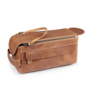 Side-front view of the handcrafted leather shave bag showing the sturdy handle and YKK zippers.