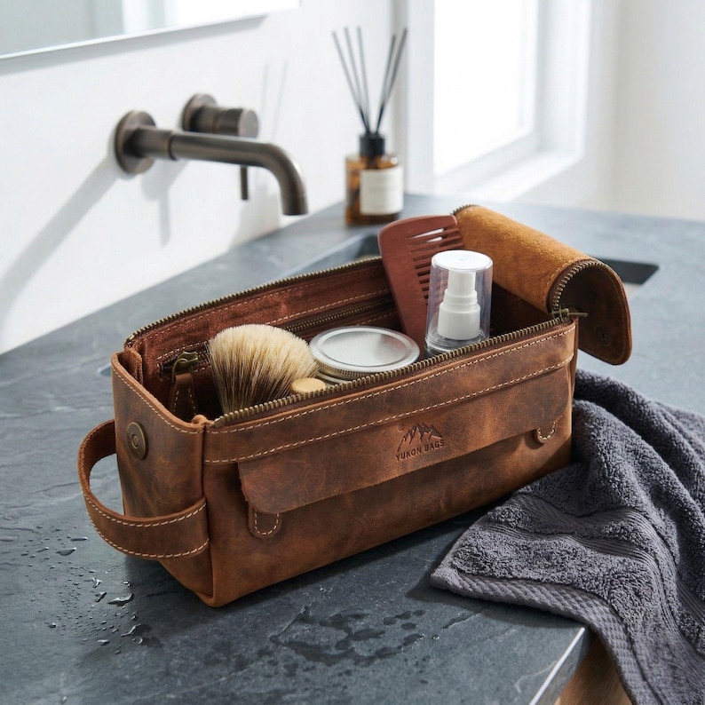 Professional leather wash bag for men placed on a high-end dark marble bathroom vanity.