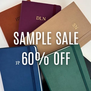 Puede incluir: Seis cuadernos de diferentes colores con iniciales personalizadas en la parte delantera. Los cuadernos están apilados uno encima del otro. El texto "SAMPLE SALE 60% OFF" está superpuesto en la imagen.