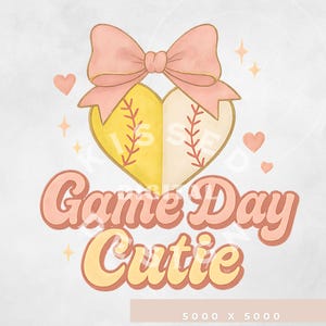 May include: A pink bow with a yellow and white heart-shaped softball with the text "Game Day Cutie" in pink and yellow lettering.