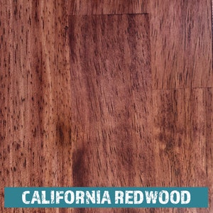 May include: Close-up of a rich, reddish-brown wood grain surface. The wood has a natural, rustic look with a subtle sheen. The text "CALIFORNIA REDWOOD" is printed in white on a teal blue background at the bottom of the image.