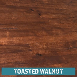 May include: Close-up of a wood surface stained in a rich, dark brown color called "Toasted Walnut". The wood grain is visible and has a natural, rustic look.