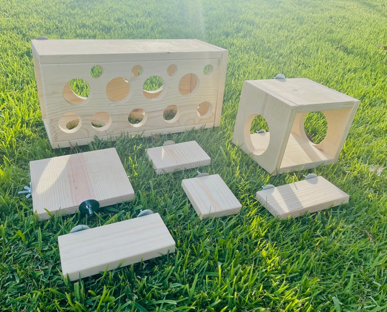 May include: A set of wooden enrichment toys for small animals, including a tunnel, a cube, and several platforms. The toys are made of natural wood and have a light brown color.