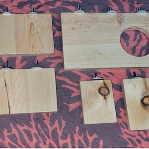 May include: Five wooden shelves with metal brackets. The shelves are made of natural wood and have a light brown color. The shelves are all different sizes and shapes.