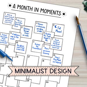 May include: A white paper with the title "A Month in Moments" and a minimalist design. The calendar-style layout includes numbered boxes with handwritten notes, a blue pen, and a succulent plant.