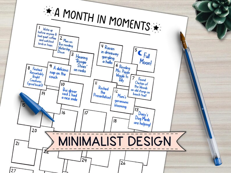 May include: A white paper with the title "A Month in Moments" and a minimalist design. The calendar-style layout includes numbered boxes with handwritten notes, a blue pen, and a succulent plant.