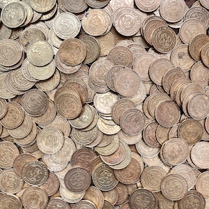 May include: A large pile of gold-colored tokens with the words "Where a Kid Can Be a Kid" and "2003" printed on them.