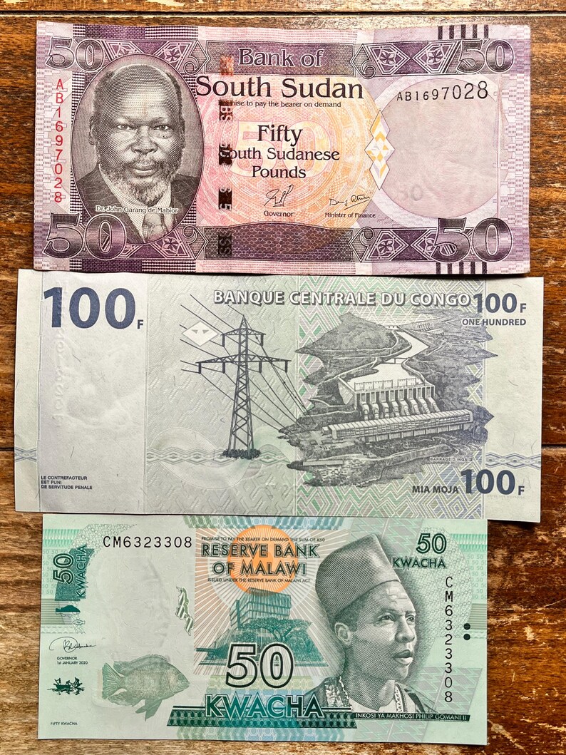 K&ouml;nnte beinhalten: Drei verschiedene Banknoten aus S&uuml;dsudan, Kongo und Malawi. Die s&uuml;dsudanische Banknote ist rosa und lila mit einem Portr&auml;t eines Mannes. Die kongolesische Banknote ist gr&uuml;n und zeigt ein Wasserkraftwerk. Die malawische Banknote ist gr&uuml;n und zeigt ein Portr&auml;t eines Mannes.