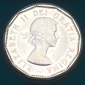 May include: A silver Canadian coin with a portrait of Queen Elizabeth II and the text "ELIZABETH II DEI GRATIA REGINA" around the edge.