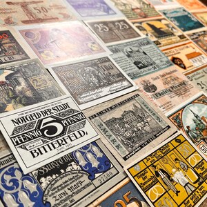 May include: A collection of vintage German banknotes, featuring various denominations and designs. The notes display intricate illustrations, text, and dates, showcasing historical currency from the early 20th century. The banknotes are in shades of black, white, blue, yellow, and brown.