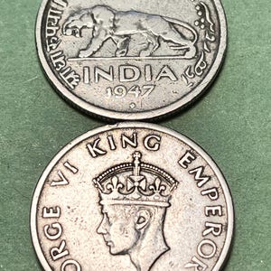 May include: Two silver coins. The top coin reads "HALF RUPEE" and "INDIA 1947" with a lion image. The bottom coin features a profile of a person with a crown and the text "GEORGE VI KING EMPEROR".