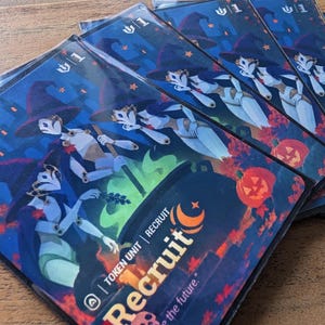 Puede incluir: Una pila de cartas de juego rectangulares con una escena nocturna azul oscuro que muestra figuras estilizadas con sombreros puntiagudos y máscaras. Las cartas muestran un caldero verde brillante, calabazas naranjas y el texto Recruit Token Unit.