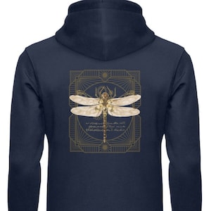 Può includere: Felpa con cappuccio blu navy con cerniera, con un'illustrazione dorata di libellula all'interno di una cornice decorativa. Il testo all'interno della cornice recita "Se dimentichi, ti ricorderai. Se ti ricordi, devi dimenticare. Più è bello, più fa male."
