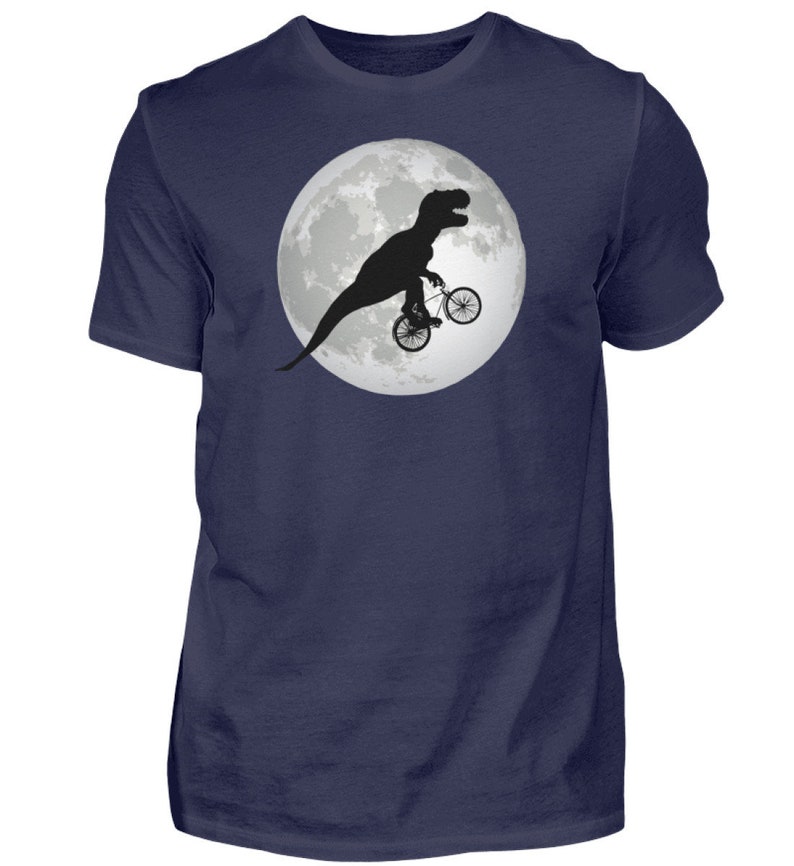 May include: A navy blue t-shirt with a graphic of a black silhouette of a dinosaur riding a bicycle in front of a full moon.