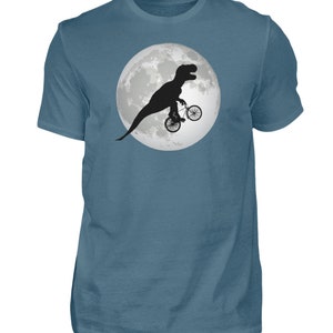 May include: A blue t-shirt with a graphic of a dinosaur riding a bicycle in front of a full moon.