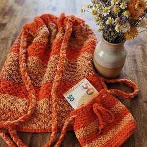 Conjunto de bolso de punto, bolso de mano con cordón y rayas naranjas con estuche a juego.