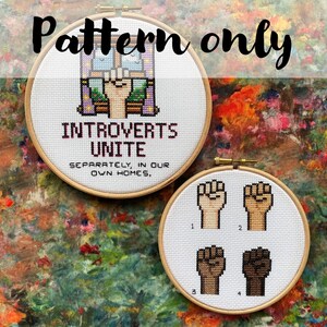 Könnte beinhalten: Zwei Kreuzstichreifen mit dem Text "INTROVERTS UNITE" und "SEPARATELY, IN OUR OWN HOMES." Der zweite Reifen zeigt vier Fäuste mit unterschiedlichen Hauttönen. Die Worte "Pattern only" stehen über den Reifen.