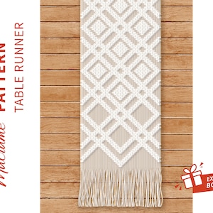 Peut inclure: Chemin de table en macramé crème avec un motif géométrique en losanges sur un fond beige. Le chemin de table a une bordure à franges. Les mots "PATTERN TABLE RUNNER" sont imprimés sur le côté gauche.