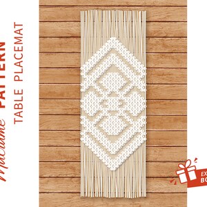 May include: White macrame table placemat with a geometric pattern, hanging against a wooden backdrop.