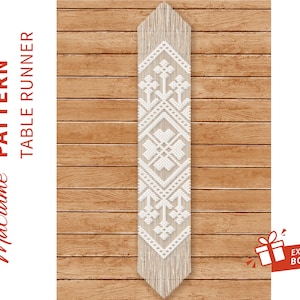 以下が含まれることがあります： 木製の背景に幾何学模様の白いマクラメテーブルランナー。画像の左側に赤い文字で「Macrame PATTERN TABLE RUNNER」と書いてあります。画像の右下に白いギフトアイコンと「EXTRA BONUS」の文字が書かれた赤いボックスがあります。