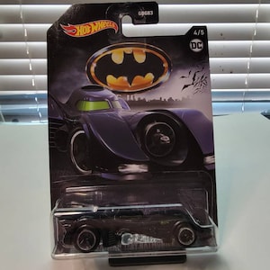 Pu&ograve; includere: Un'auto giocattolo nera in metallo pressofuso Hot Wheels della Batmobile di Batman del 1989. L'auto &egrave; in una confezione blister di plastica con un logo Batman nero e giallo. La confezione contiene anche il testo "Hot Wheels", "DC" e "4/5".