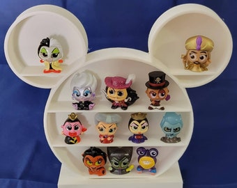 Könnte beinhalten: Ein weißer Mickey-Mouse-förmiger Präsentationsständer mit 11 kleinen Plastikfiguren von Disney-Schurken. Die Figuren sind in den verschiedenen Fächern des Ständers angeordnet.