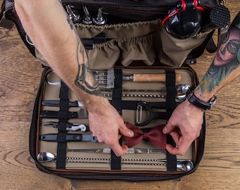 May include: A brown leather bar tool kit with a variety of tools, including a muddler, jigger, strainer, and bottle opener. The kit is open and the tools are visible. A red bow tie is in the center of the kit.