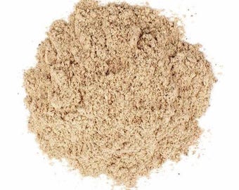 May include: A pile of finely ground, light beige powder with a granular texture. The substance appears dry and consists of small, uniform particles that form an irregular, rounded mound against a plain white background, showing consistent color.