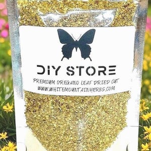 May include: A clear plastic bag filled with dried oregano leaves. The bag has a white label with a black butterfly silhouette and the words "DIY STORE". Below the logo, it reads "PREMIUM OREGANO LEAF DRIED CUT" and "WWW.WHITEMOUNTAINHERBS.COM".