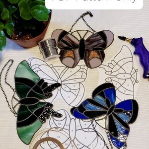 May include: A stained glass butterfly craft kit with three different butterfly patterns. The kit includes the glass pieces, lead came, and instructions. The text "PDF Pattern Only" is visible in the image.
