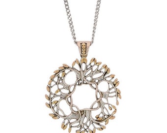 May include: A silver and gold necklace with a circular pendant featuring a stylized tree of life design. The pendant is detailed with intricate branches and leaves.
