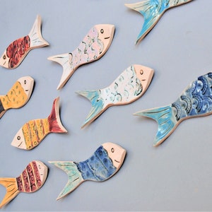 Wall hanging fish shoal art tiles. Nautical theme quirky wall decor for coastal seaside home or bathroom. Handmade uk pottery.