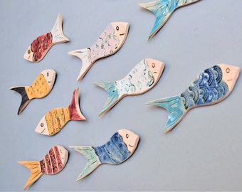 Wall hanging fish shoal art tiles. Nautical theme quirky wall decor for coastal seaside home or bathroom. Handmade uk pottery.