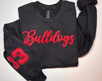 May include: Black sweatshirt with red embroidered text "Bulldogs" and a red number "63" on the sleeve.