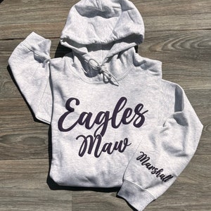 以下が含まれることがあります： グレーのフード付きスウェットシャツ。前面に「Eagles Maw」という黒い筆記体で書かれた文字と、左袖に「Marshall」という黒い文字が書かれている。