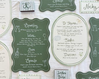 May include: A set of green and white wedding menu cards with handwritten text. The cards include a list of drinks, food, and sides. The cards are decorated with small drawings of flowers, lemons, and wine glasses.