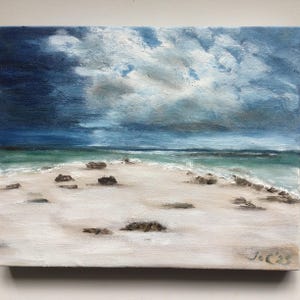 May include: An oil painting of a beach scene with a dramatic sky. The sky transitions from dark blue to lighter shades, with fluffy white clouds. The beach has white sand, small rocks, and turquoise water.