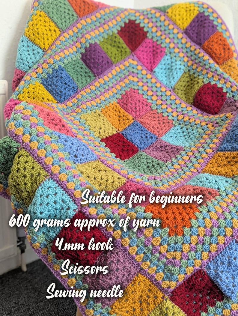 May include: A colorful, handmade crochet blanket with a patchwork design. The blanket features squares in various colors, including yellow, blue, green, pink, and purple. The text on the blanket says "Suitable for beginners", "600 grams approx of yarn", "4mm hook", "Scissors", and "Sewing needle".