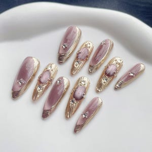 Vallende kersenzijde, handgemaakte nagels, cat-eye gouden randlijnsfeer, zachte bruiloftsmanicure, opdruknagels, lange amandelnagels